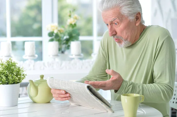 Känslomässiga Senior Man Läsa Tidningen Hemma — Stockfoto