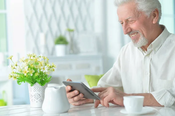 Evde Tablet Kullanan Gülümseyen Yaşlı Adamın Portresi — Stok fotoğraf