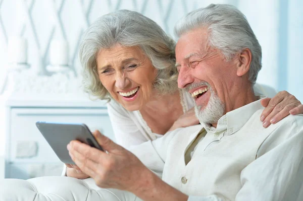 家庭でタブレットを使って幸せな老夫婦の肖像画です — ストック写真