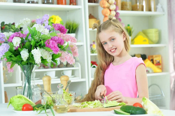 可愛いです女の子準備おいしい新鮮なサラダでキッチン — ストック写真