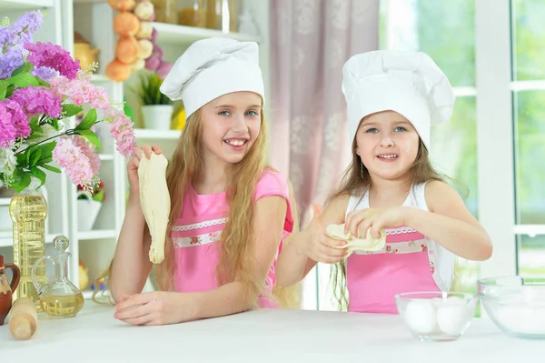 可爱的小女孩在厨师帽子做面团在厨房在家庭 — 图库照片