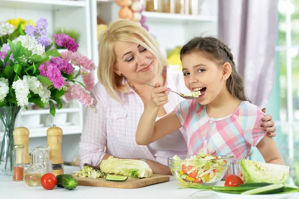 可愛いです女の子とともに彼女のお母さん料理とともにキッチンテーブル — ストック写真