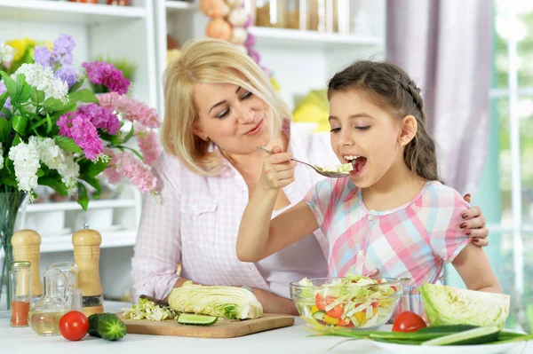 可愛いです女の子とともに彼女のお母さん料理とともにキッチンテーブル — ストック写真