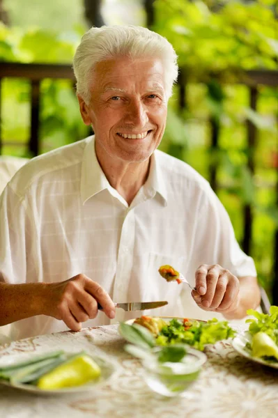 屋外健康的な朝食を食べるハンサムな年配の男性の肖像画 — ストック写真