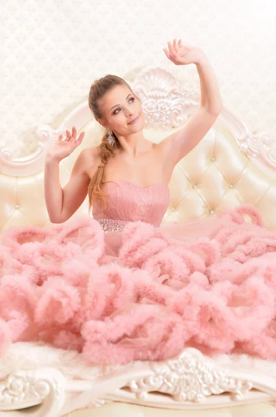 Yatak Odasında Poz Pembe Elbiseli Güzel Genç Kadın — Stok fotoğraf