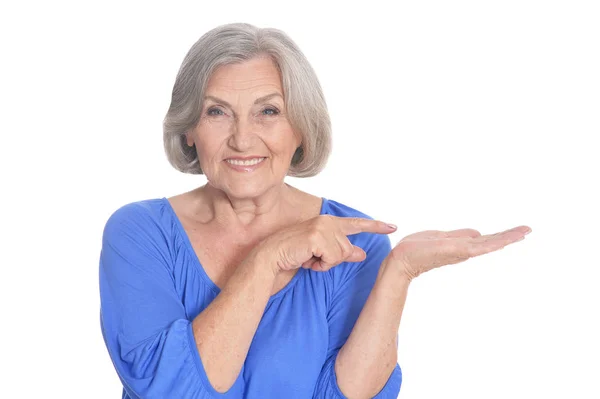 Portrait Smiling Senior Woman Pointing Something Her Palm Isolated White — Stock Photo, Image