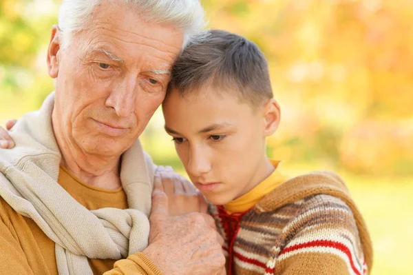 悲しい祖父と孫が公園で抱き合って — ストック写真