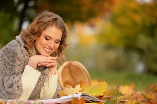 美丽的年轻女子在公园里读书 — 图库照片