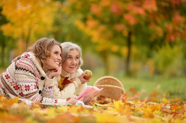 秋の公園で休んでいる娘と年配の女性 — ストック写真