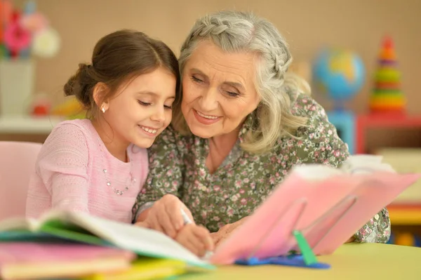 Großmutter Mit Süßem Kleinen Mädchen Beim Hausaufgabenmachen — Stockfoto