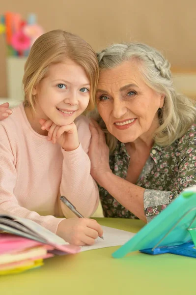 Mormor Med Söt Liten Flicka Göra Läxor Tillsammans — Stockfoto