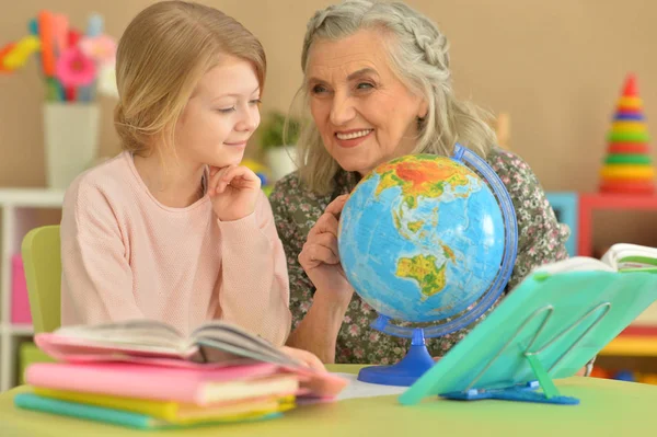 祖母与逗人喜爱的小女孩一起做家庭作业 — 图库照片