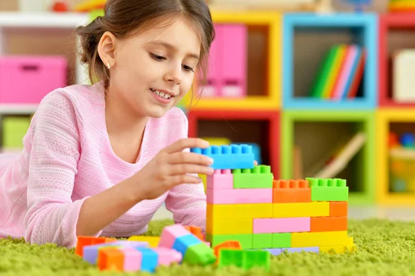カラフルなプラスチック製のブロックで遊んで巻き毛の小さな女の子 — ストック写真