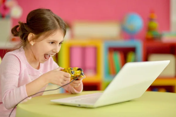 可爱的小女孩 使用现代笔记本电脑和玩游戏 — 图库照片