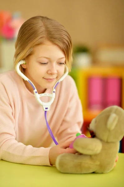 可爱的小女孩当护士 用听诊器检查泰迪熊 — 图库照片