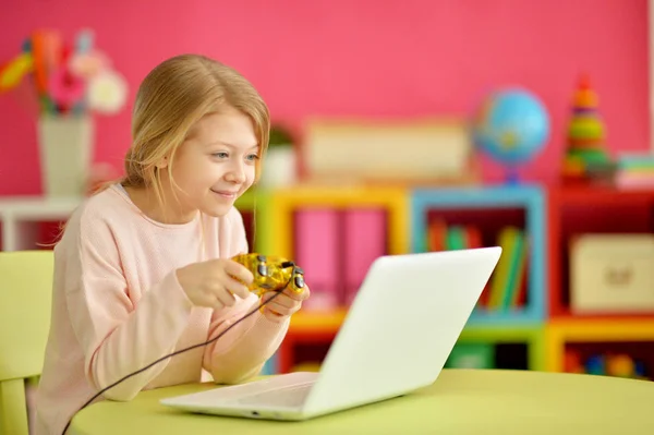 可爱的小女孩 使用现代笔记本电脑和玩游戏 — 图库照片
