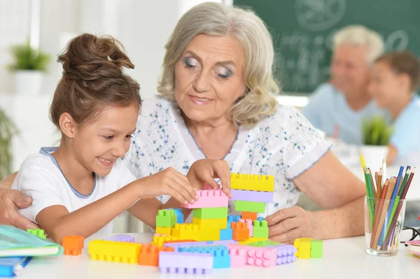 Söt Flicka Och Mormor Leker Med Färgglada Plastblock — Stockfoto