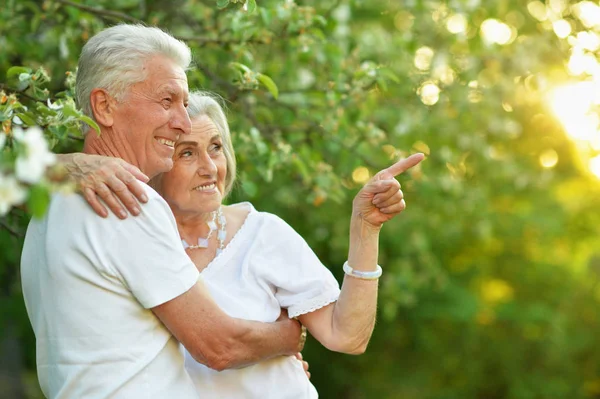 Beautiful Senior Couple Hugging Park Woman Pointing Finger — Stock Photo, Image