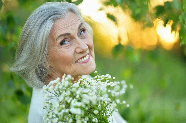 Mulher Sênior Feliz Com Flores Parque — Fotografia de Stock