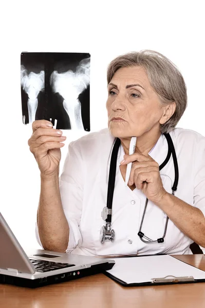 線を見るとコンピューターのテーブルに座って深刻な高齢者の女性の医者 — ストック写真