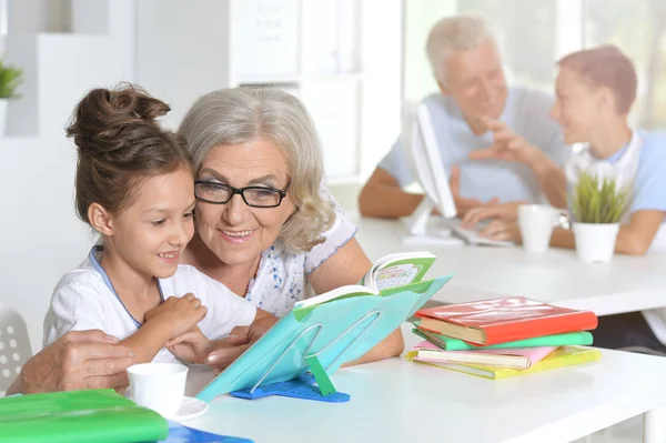 Großmutter Mit Süßem Kleinen Mädchen Beim Hausaufgabenmachen — Stockfoto