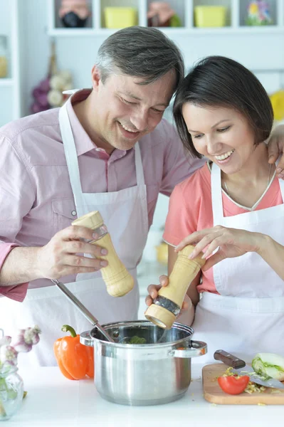 幸せな夫と妻がキッチンで一緒に料理をする — ストック写真