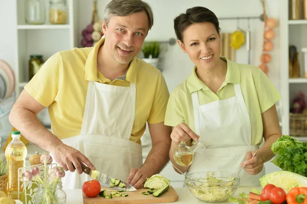 幸せな夫と妻がキッチンで一緒に料理をする — ストック写真