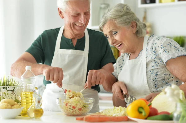 Senior couple cooking together at kitchen