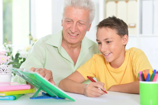 Бабушка с внуком делают домашнее задание — стоковое фото