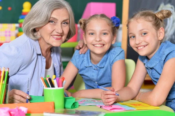 Mulher sênior com meninas desenho — Fotografia de Stock