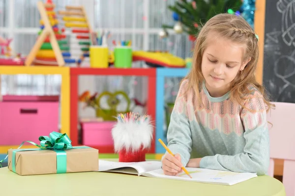 Cute Girl Siedzi Przy Stole Darem — Zdjęcie stockowe