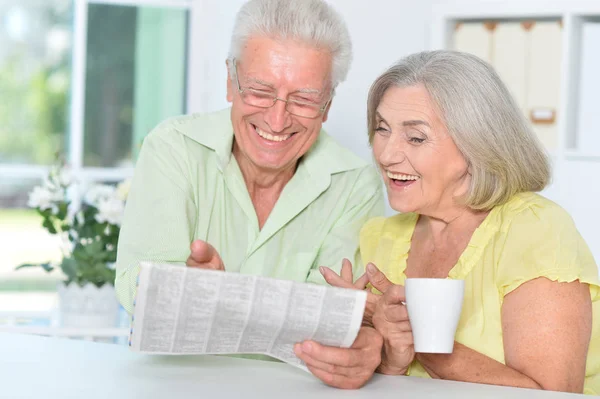 Seniorenpaar Zit Aan Tafel Leest Krant — Stockfoto