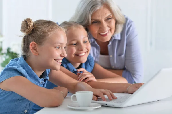 Oma met kleindochters laptop gebruikt — Stockfoto