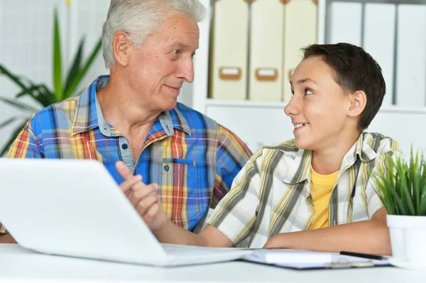 Lachende Grootvader Met Kleinzoon Met Laptop Thuis — Stockfoto