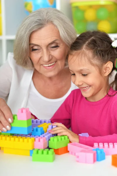 可愛いです女の子と祖母遊びますカラフルなプラスチックブロック — ストック写真