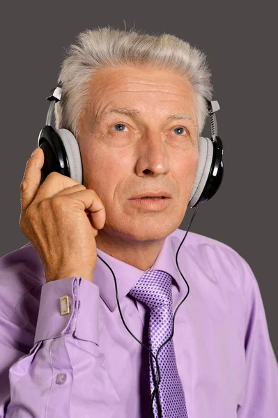 老年人在耳机里听音乐 — 图库照片
