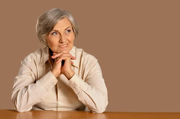坐在餐桌前的快乐老年妇女的肖像 — 图库照片