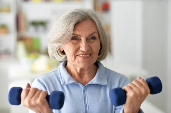 Elderly woman exercising in gym — Stock Photo, Image