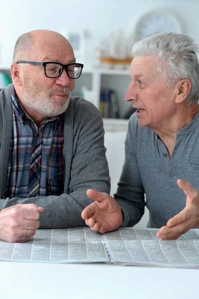 Twee Senior Mannen Zitten Aan Tafel Lezen Van Krant — Stockfoto