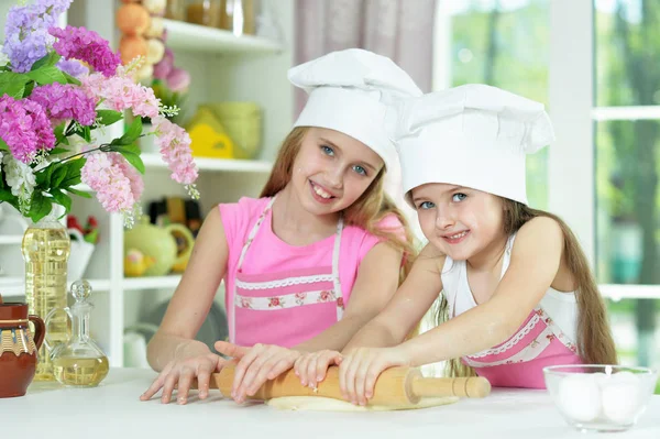 可爱的小女孩戴着帽子在厨房里做面团 — 图库照片