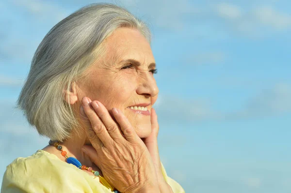 Счастливая Пожилая Женщина Позирует Фоне Голубого Неба — стоковое фото
