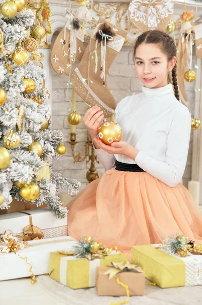 用地板上的礼物装饰圣诞树的快乐女孩的画像 — 图库照片