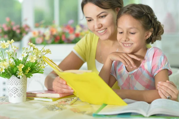 Pequeña Linda Chica Leyendo Libro Con Madre Mesa Casa —  Fotos de Stock