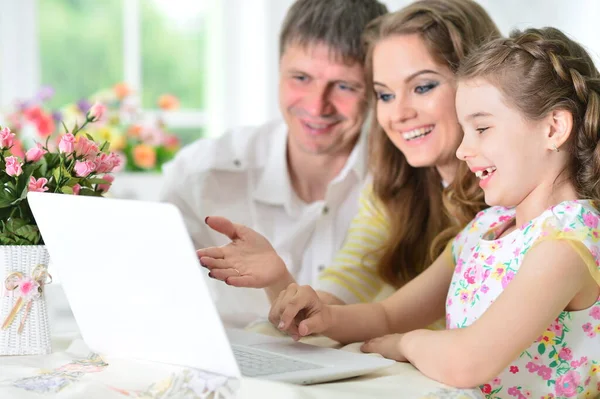 両親と娘が部屋にノートパソコンを使って — ストック写真