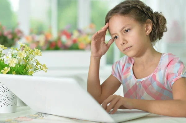 一个体贴可爱的女孩在家里用笔记本电脑 — 图库照片