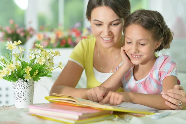 Pequeña Linda Chica Leyendo Libro Con Madre Mesa Casa —  Fotos de Stock