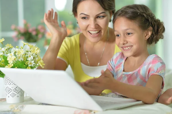 ノートパソコンを使った笑顔の母親と娘の肖像画 — ストック写真