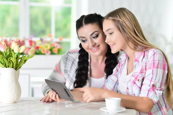 Gülümseyen Anne Kız Masada Oturuyor Dijital Tablet Kullanıyor — Stok fotoğraf