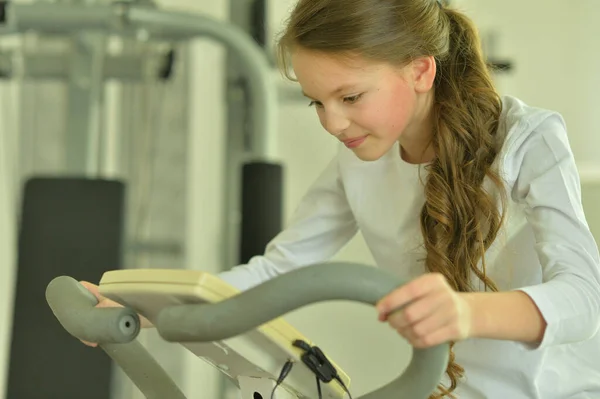 Spor Salonunda Bisiklet Egzersizleri Yapan Küçük Bir Kız — Stok fotoğraf
