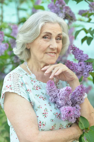 Detailní záběr portrét šťastné seniorské krásné ženy na šeříku pozadí — Stock fotografie